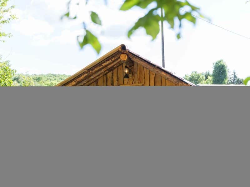 Cabane en bois en Alsace, avec un éclairage suspendu et vue sur la nature.