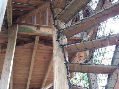 Cabane dans les arbres en Bourgogne, avec un escalier en bois et des filets de protection.