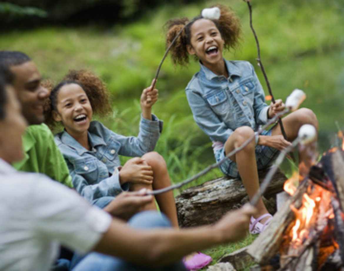 Hébergement insolite en pleine nature, famille rassemblée autour dun feu de camp.