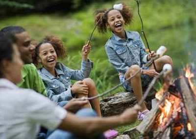 Hébergement insolite en pleine nature, famille rassemblée autour dun feu de camp.