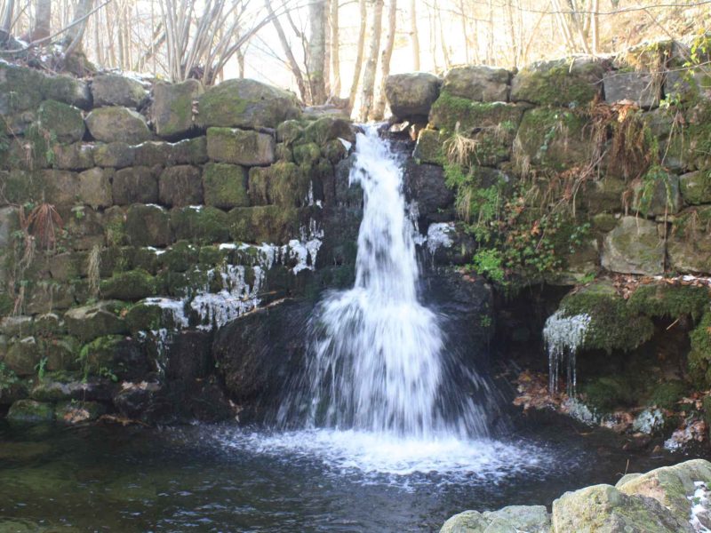 Hébergement en pleine nature avec une cascade apaisante et des rochers verdoyants.