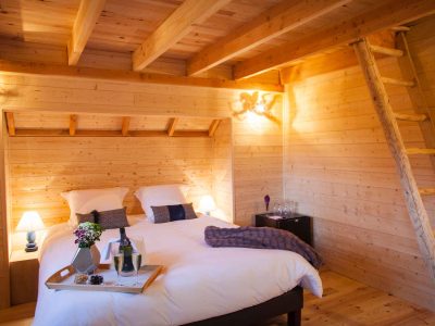 Chalet en bois chaleureux avec lit douillet et décoration en bois naturel.