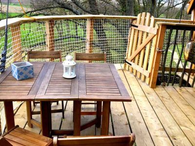 Cabane perchée en Bourgogne avec terrasse en bois et vue sur la nature environnante.