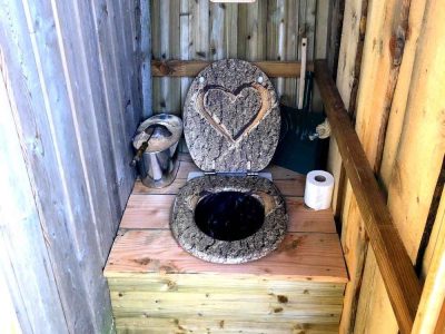 Toilettes sèches en bois avec un couvercle en forme de cœur, hébergement insolite en Bourgogne.