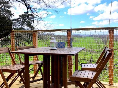 Cabane perchée en Bourgogne avec terrasse en bois et vue panoramique sur la nature.