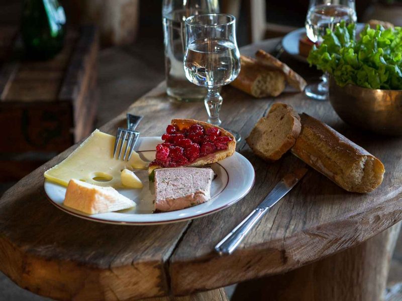 Table rustique avec un plat de fromages et charcuterie, idéale pour un séjour en gîte.
