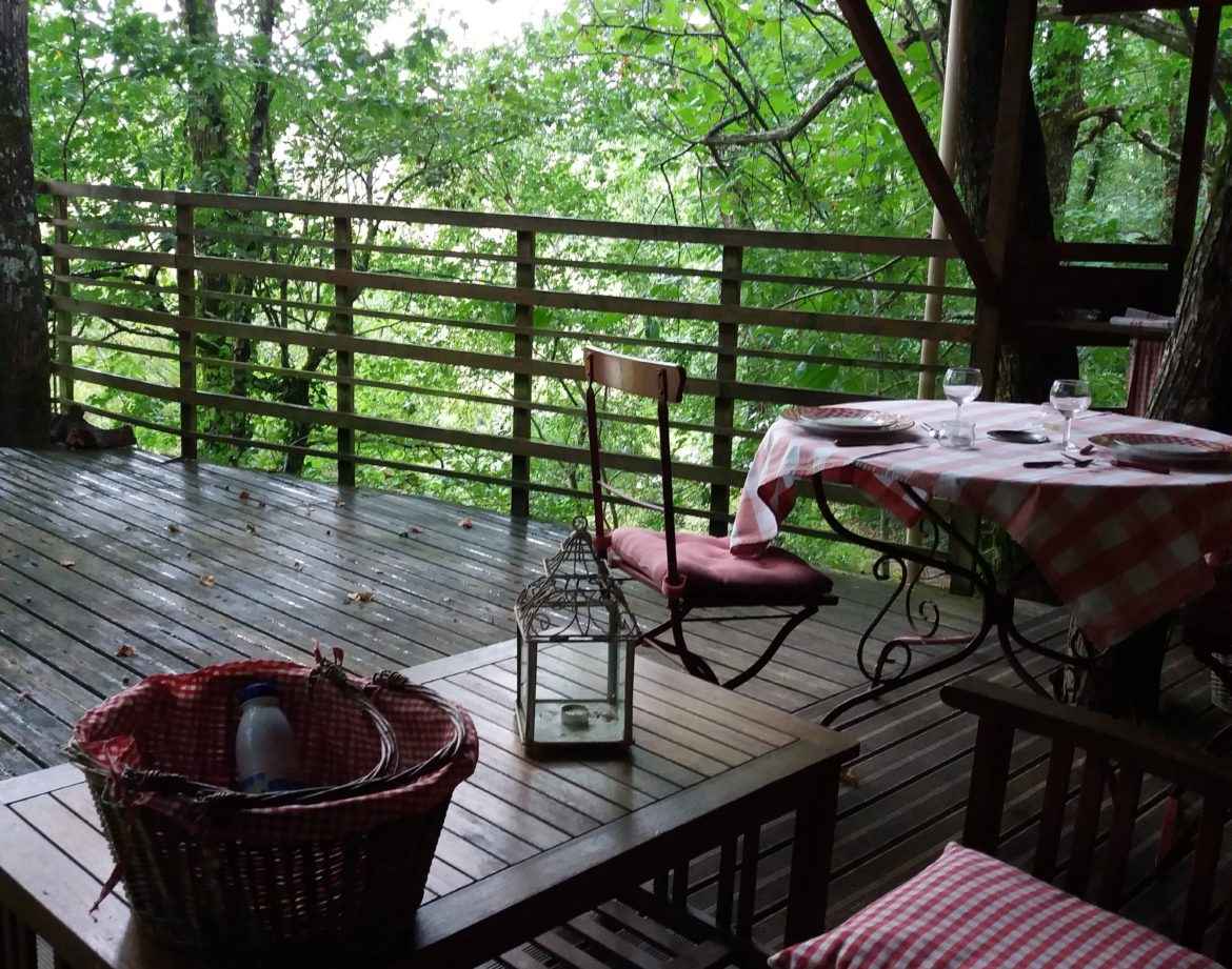 Cabane perchée en Nouvelle-Aquitaine, avec terrasse en bois et vue sur la forêt.