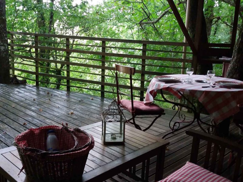 Cabane perchée en Nouvelle-Aquitaine, avec terrasse en bois et vue sur la forêt.