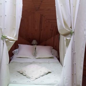 Chambre cocooning en bois, drapée de rideaux, au cœur de la Nouvelle-Aquitaine.