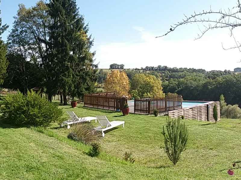 Gîte rural avec jardin verdoyant et piscine, entouré de nature paisible.