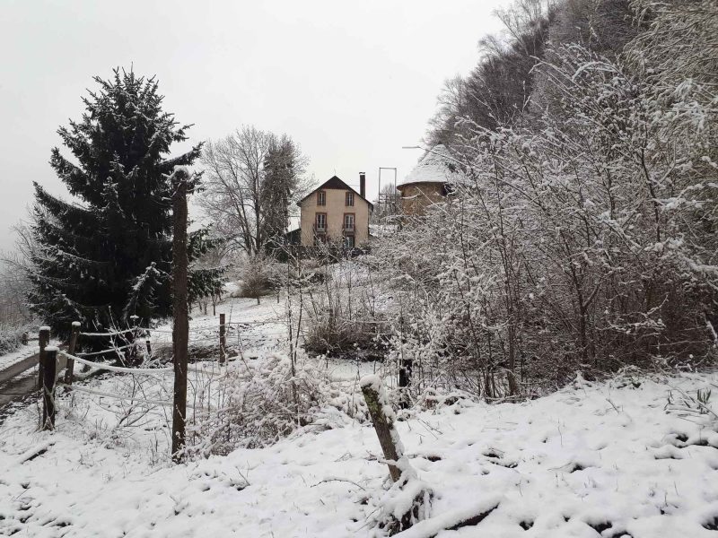Chalet en bois entouré de neige, offrant une vue paisible sur la nature.