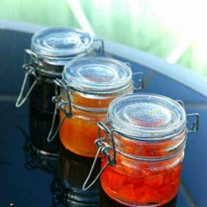 Trois pots de confiture artisanale sur une table en verre, hébergement insolite en