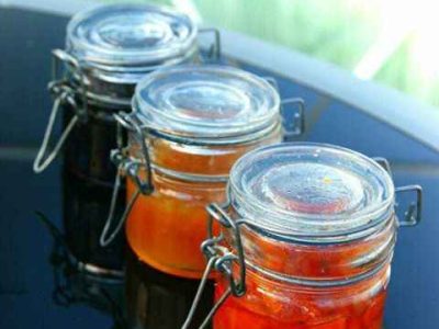 Trois pots de confiture artisanale sur une table en verre, hébergement insolite en
