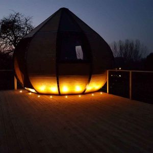 Hébergement insolite en forme de bulle, illuminé au crépuscule, en Nouvelle-Aquitaine.