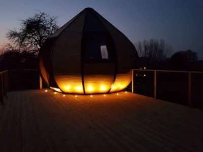 Hébergement insolite en forme de bulle, illuminé au crépuscule, en Nouvelle-Aquitaine.