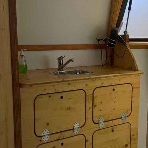 Hébergement insolite en Nouvelle-Aquitaine : intérieur en bois avec lavabo et miroir.