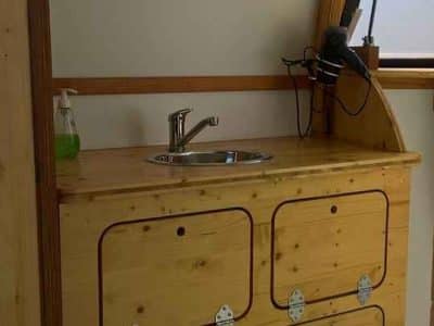 Hébergement insolite en Nouvelle-Aquitaine : intérieur en bois avec lavabo et miroir.