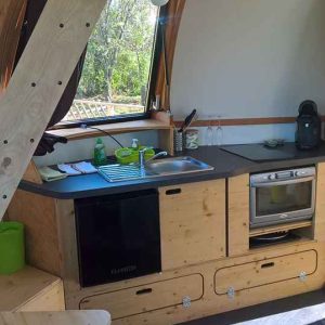 Hébergement insolite en Nouvelle-Aquitaine : cuisine moderne en bois avec lumière naturelle.