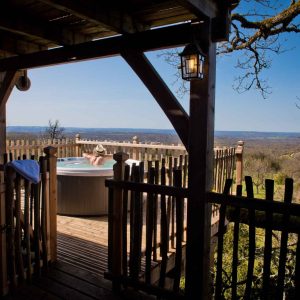 Cabane perchée en Midi-Pyrénées avec jacuzzi et vue panoramique sur la nature.