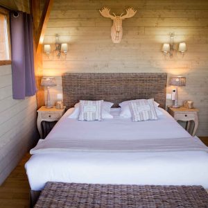Chalet en bois cosy à Midi-Pyrénées, avec lit douillet et décor chaleureux.
