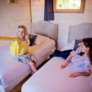 Chalet en bois à Midi-Pyrénées, avec deux lits simples et ambiance chaleureuse.