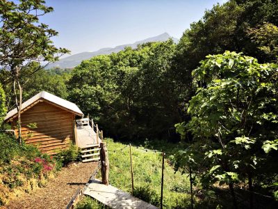 Cabane en bois nichée dans la verdure, avec vue sur les montagnes en Aquitaine.