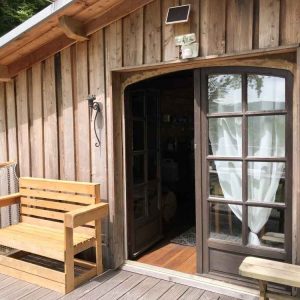 Cabane en bois à Limousin avec une belle terrasse en bois et une porte vitrée.