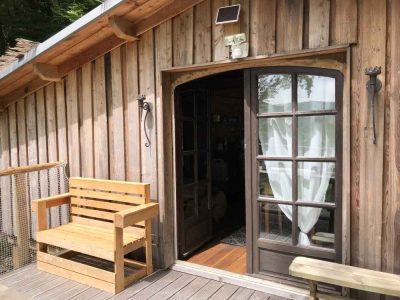 Cabane en bois à Limousin avec une belle terrasse en bois et une porte vitrée.