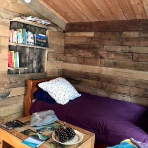 Hébergement insolite en bois dans le Limousin, avec un lit confortable et une bibliothèque.