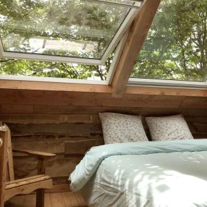 Cabane en bois à Limousin, avec vue sur la nature grâce à de grandes fenêtres.