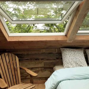 Cabane en bois à Limousin, avec un lit confortable et un toit vitré sur la nature.