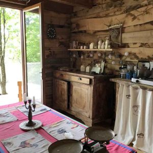 Cabane en bois dans le Limousin, avec une cuisine rustique et vue sur la nature.