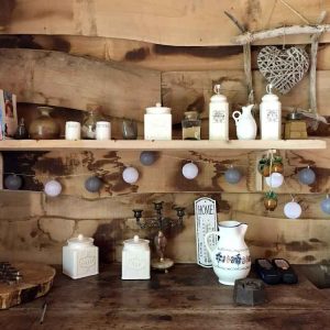 Hébergement insolite en Limousin : intérieur en bois avec étagères décorées et lumière douce.