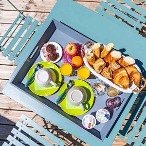 Petit-déjeuner gourmand servi sur une terrasse en bois, hébergement insolite en Auvergne.