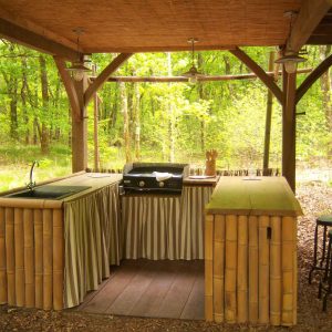 Hébergement insolite en Aquitaine : cuisine en bambou au cœur de la forêt verdoyante.