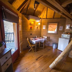 Cabane en bois à Provence-Alpes-Côte dAzur, avec table à manger et vue sur la nature.