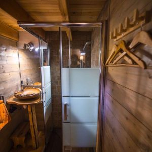 Cabane en bois avec douche moderne et éléments en bois chaleureux.
