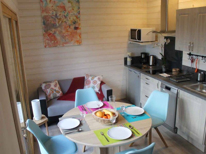 Chalet moderne avec cuisine équipée et coin repas lumineux, décoré avec goût.