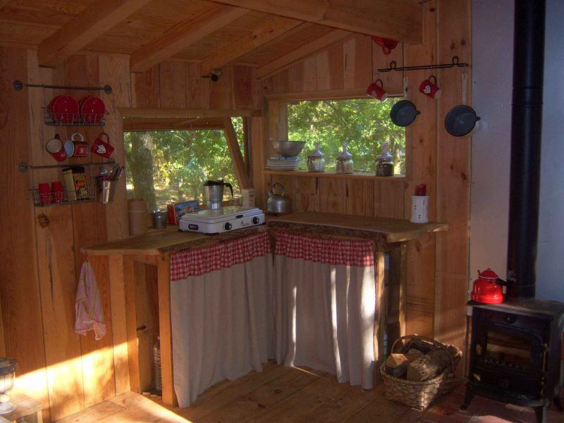 Cabane en bois en Aquitaine avec cuisine rustique et vue sur la nature.