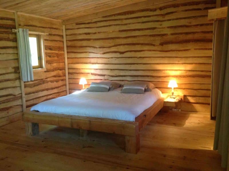 Chalet en bois avec lit king-size et ambiance chaleureuse.