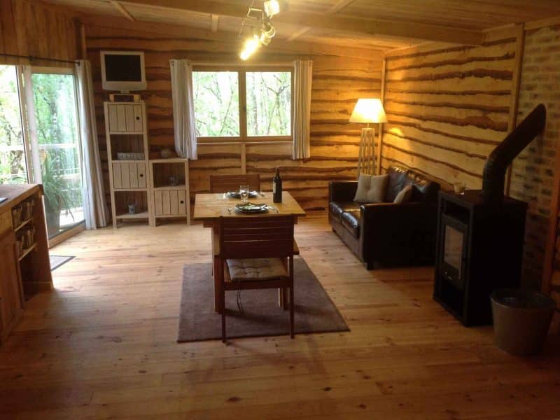 Chalet en bois chaleureux avec un coin salon et une vue sur la nature.