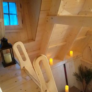 Cabane en bois avec un intérieur chaleureux et des bougies lumineuses.