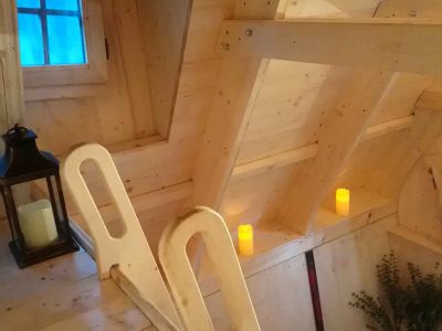 Cabane en bois avec un intérieur chaleureux et des bougies lumineuses.