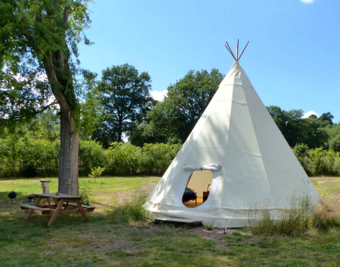 Tipi confortable en Auvergne, entouré de verdure et dun espace détente.