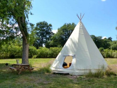 Tipi confortable en Auvergne, entouré de verdure et dun espace détente.