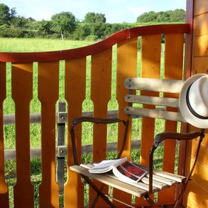 Hébergement insolite en Auvergne-Rhône-Alpes, avec une chaise en bois et un chapeau sur le dossier.