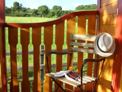 Hébergement insolite en Auvergne-Rhône-Alpes, avec une chaise en bois et un chapeau sur le dossier.