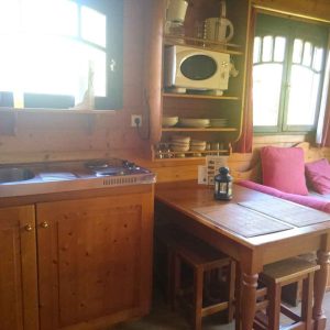 Cabane en bois cosy avec kitchenette et coin repas lumineux. Parfait pour un séjour unique.
