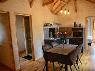 Hébergement insolite en Auvergne : chalet en bois avec cuisine moderne et décoration chaleureuse.