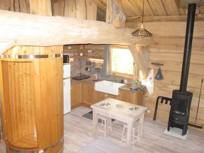 Cabane en bois à Champagne-Ardennes, avec un poêle à bois et une cuisine équipée.